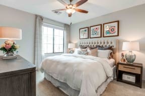 Apartments Chandler - The Core Chandler - Bedroom with Plush Carpeting, Ceiling Fan, and Large Window