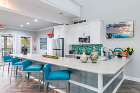 a kitchen with a large island and blue chairs