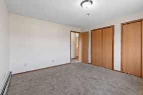 an empty living room with carpet and wood doors
