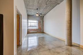 A room with a concrete floor and a ceiling fan.