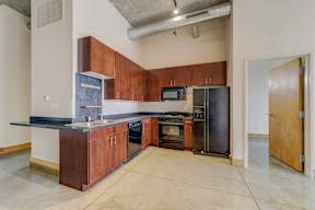 A kitchen with a black counter top and brown cabinets.
