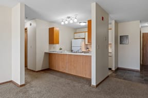 an empty kitchen with a counter top and a refrigerator