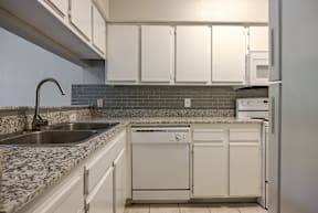 A kitchen with a sink, dishwasher and refrigerator.