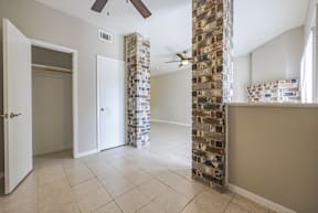 A room with a brick pillar and a ceiling fan.