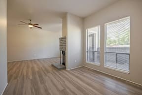 A room with a ceiling fan and wooden flooring.