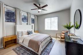 A bedroom with a large bed and a ceiling fan.