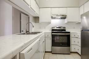 A kitchen with white cabinets and stainless steel appliances.