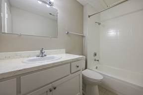 A white bathroom with a sink, toilet, and bathtub.