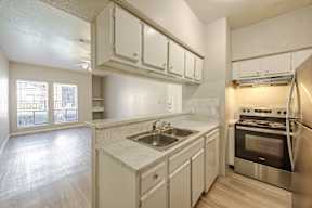 A kitchen with white cabinets and a stainless steel oven.