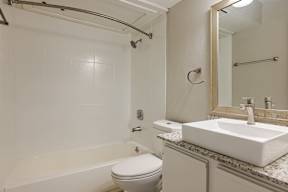 A white bathroom with a toilet, sink, and bathtub.