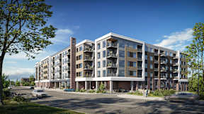 A large apartment complex with a parking lot in front.