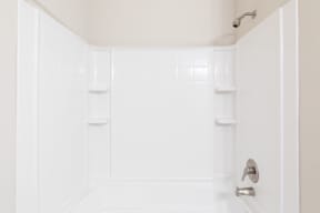a white bathroom with a shower and a sink