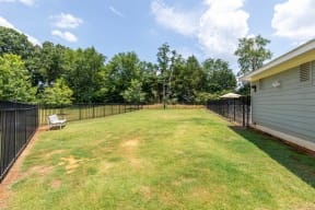 the backyard is fenced in and has a lawn and a fence