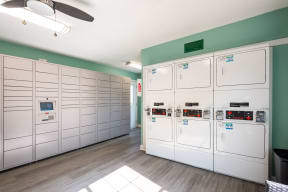 a row of white utility lockers in a room with a ceiling fan