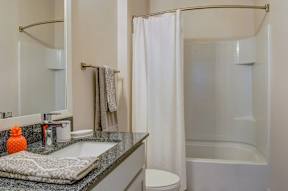 A bathroom with a white shower curtain and a white toilet.