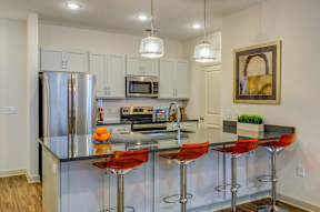A modern kitchen with a bar area and stools.