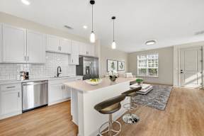 A kitchen with white cabinets and a wooden island.