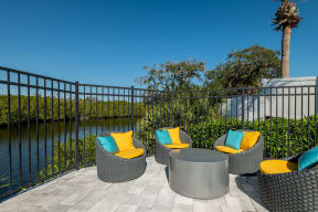 an outdoor patio with wicker chairs and a firepit