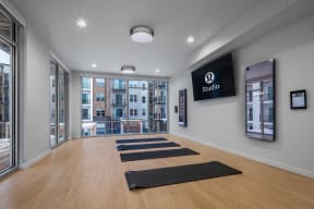 a yoga room with yoga mats on the floor and a large screen on the wall