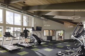 a man is running on a treadmill in a gym with large windows