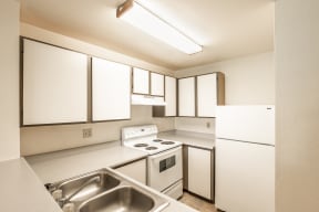 a kitchen with white cabinets and white appliances