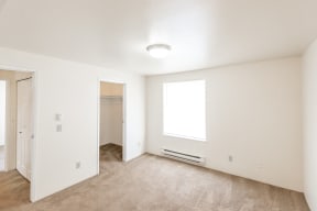 a bedroom with white walls and carpet