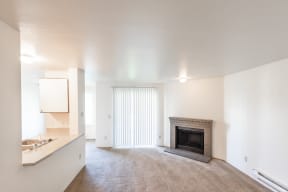 a living room with a fireplace and a kitchen
