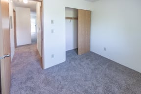 a bedroom with a closet and a carpeted floor