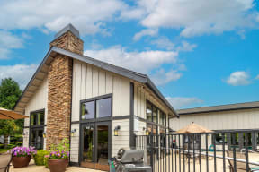 the exterior of a building with a patio and a grill