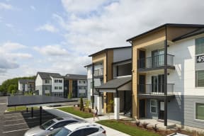 a rendering of a row of townhomes with cars parked in a parking lot