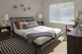 a bedroom with a bed and two windows