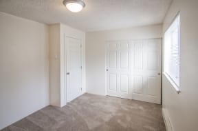 a bedroom with two doors and a carpeted floor