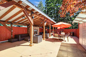 A patio with a table and chairs under a roof.