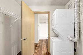 A white fridge and freezer in a kitchen with a wooden door.