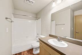 A white toilet sits next to a sink in a bathroom.