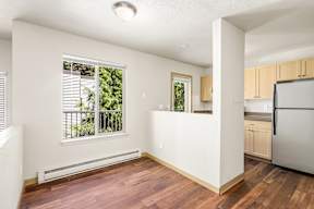 A kitchen with wooden floors and white walls.