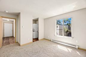 A room with a window, a door, and a wall-mounted air conditioner.
