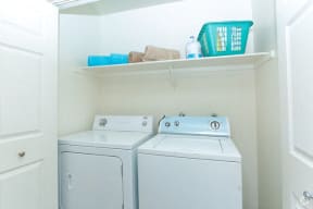 a white laundry room with two washes and a dryer
