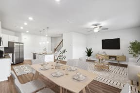 a living room and dining room with a table and chairs