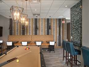 A pool table is set up in a room with additional seating