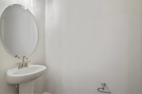 a white bathroom with a white sink and a mirror