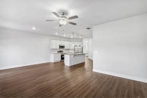 a living room with a ceiling fan and a kitchen