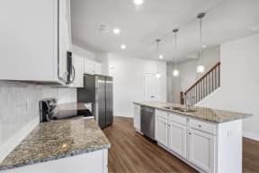 a kitchen with granite counter tops and white cabinets