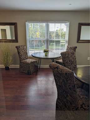 A dining room with a table and chairs.