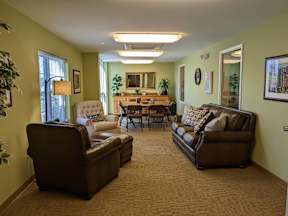 A living room with a brown couch, chair, and table.