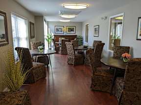 A living room with brown patterned chairs and a wooden floor.
