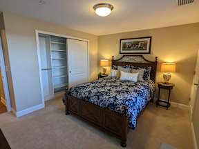 A bedroom with a large bed and a painting on the wall.