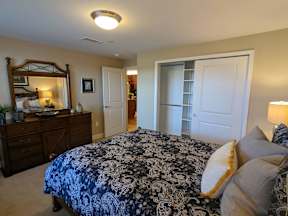 A bedroom with a bed, dresser, and mirror.