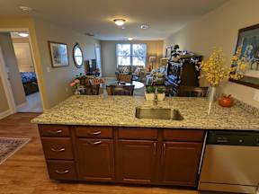A kitchen with granite countertops and wooden cabinets.