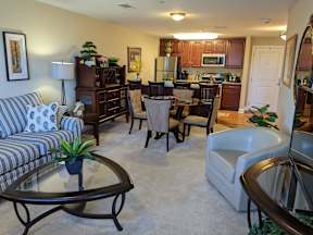 A living room with a couch, chairs, and a coffee table.